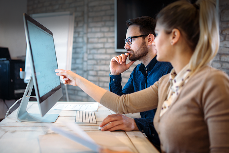 Coworkers discussing what is on computer screen