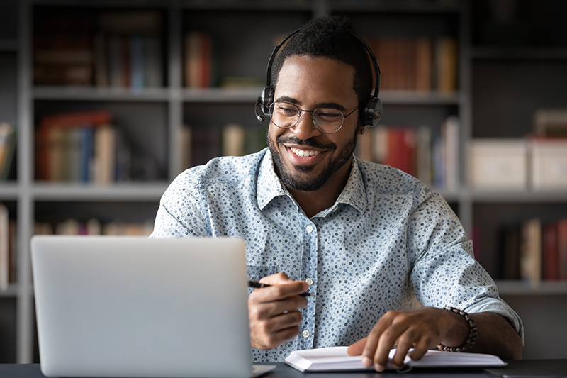 Man wearing headphones looking at laptop screen